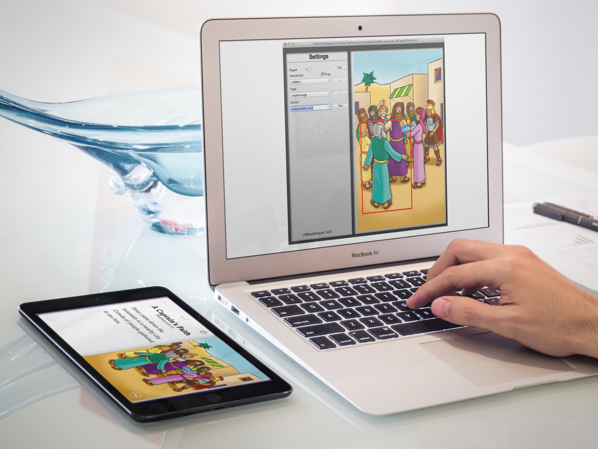 StoryBook Builder on a MacBook shows a selected illustrated character, interaction settings, and a sound file; an iPad displays the corresponding story page.